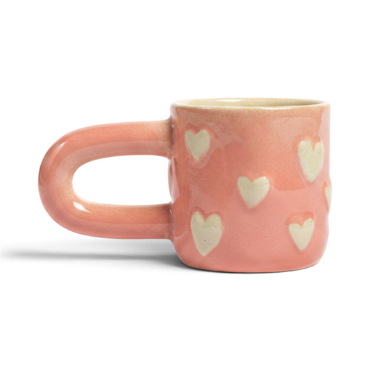 Ayethic handcrafted blush-pink ceramic mug with raised, hand-sculpted heart motifs and a comfortable rounded handle.