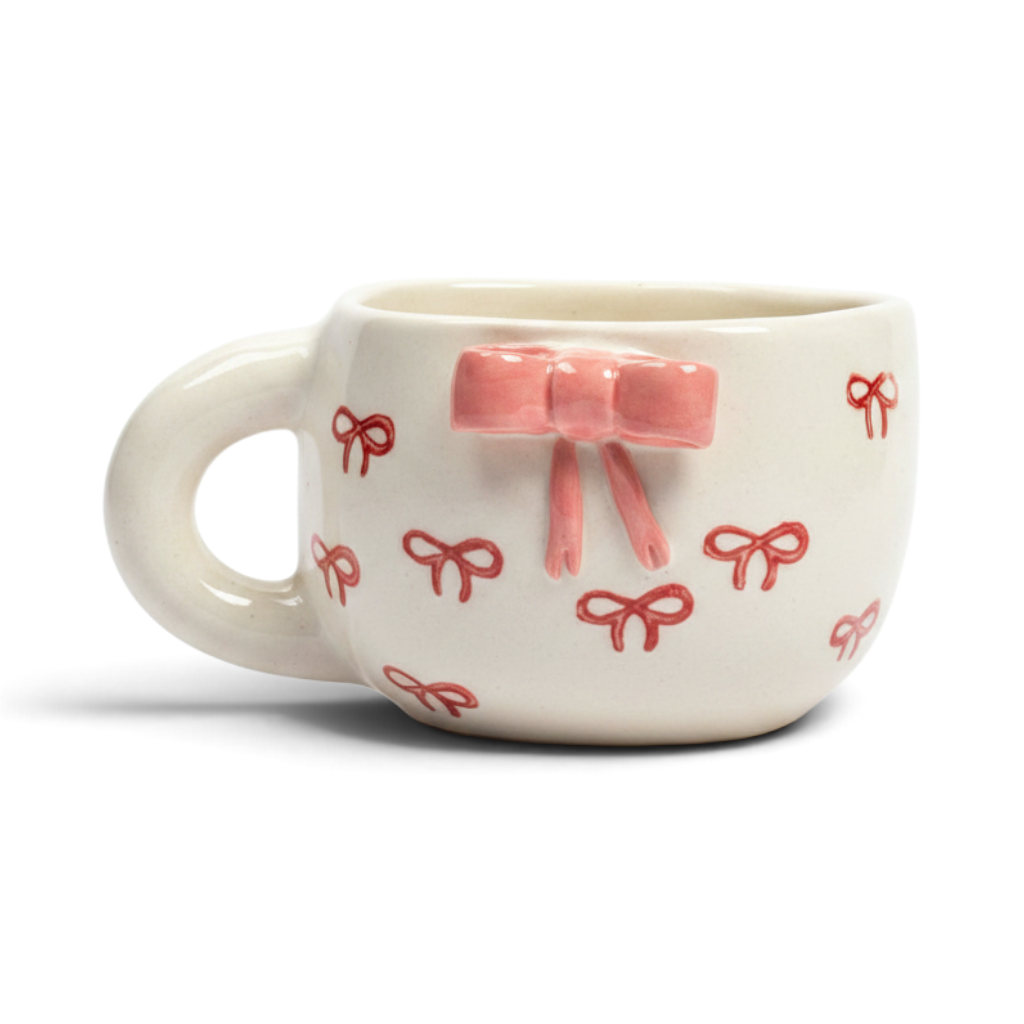 Ayethic handcrafted ceramic mug in cream with hand-painted red bows and a raised 3D pink bow accent