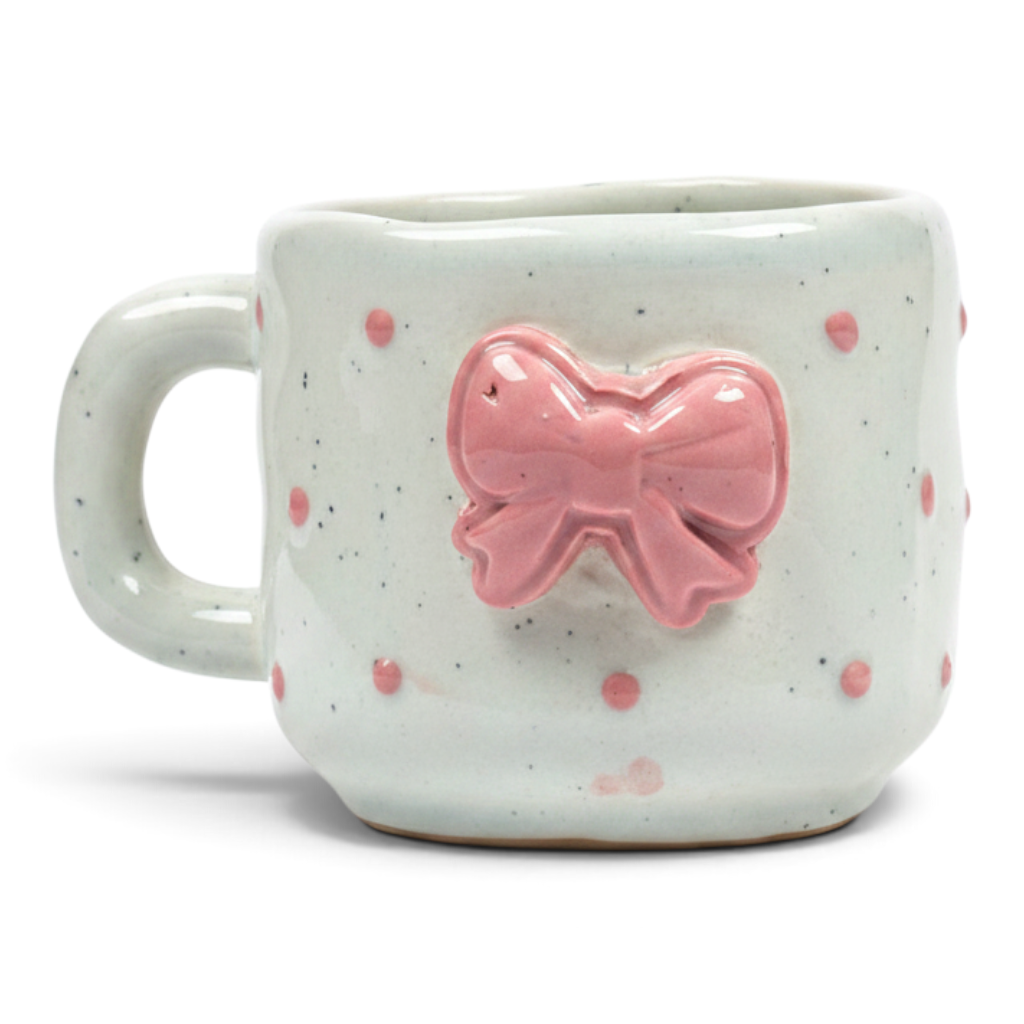 Ayethic handcrafted ceramic mug in off-white with pink polka dots and a raised pink bow detail