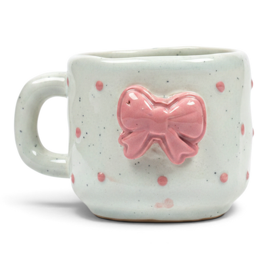 Ayethic handcrafted ceramic mug in off-white with pink polka dots and a raised pink bow detail
