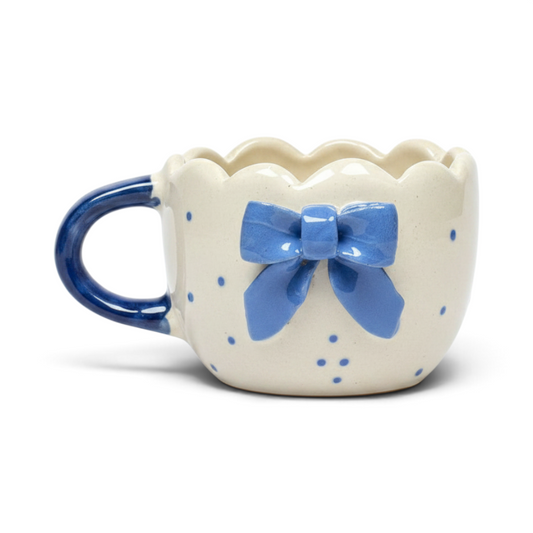 Ayethic handcrafted ceramic mug with a scalloped rim, blue polka dots, and a 3D blue bow detail.