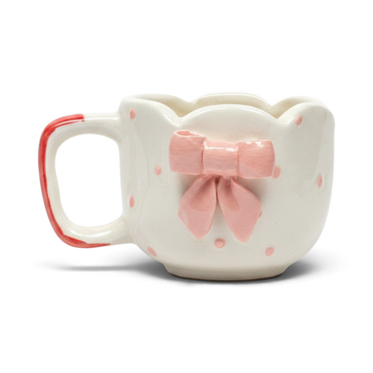 Ayethic handcrafted ceramic mug in cream with pink polka dots, a scalloped rim, and a 3D pink bow detail.