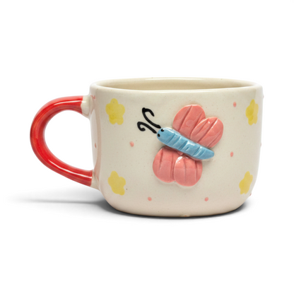 Ayethic handcrafted ceramic mug featuring a sculpted pink butterfly, yellow flowers, and a vibrant red handle.